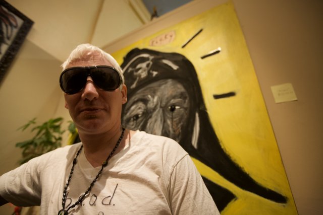 Man Gazing at Artwork in Stylish Sunglasses and White T-Shirt