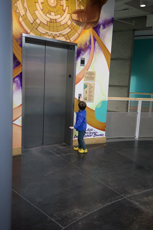 Child Exploring Interactive Elevator at Science Center