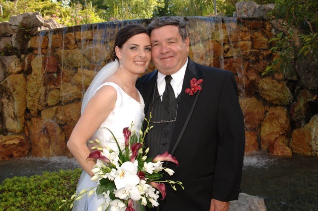 Bride and Groom Celebrate by Waterfall Feature