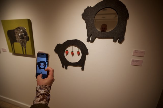 Visitor Photographing Pig Art Installation in Gallery