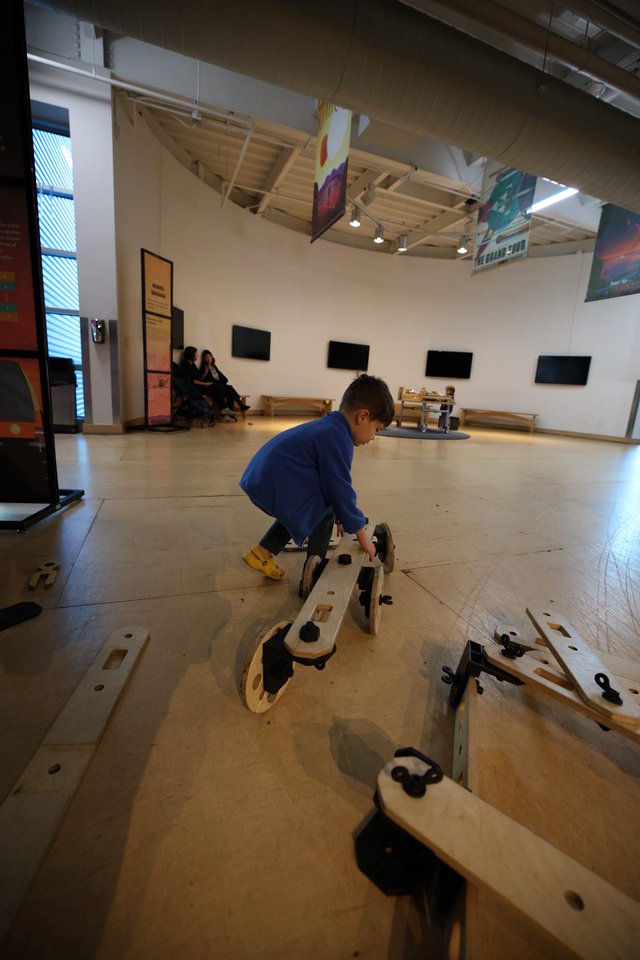 Child Playing with Wooden Construction Toy in Museum Gallery