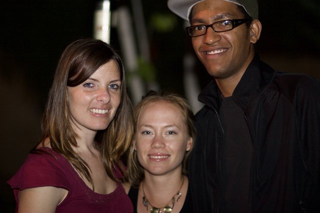Three Friends Smiling Together at Night Event