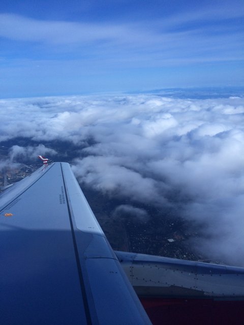 Aerial View of the Blue Sky and Clouds from an Airplane Wing