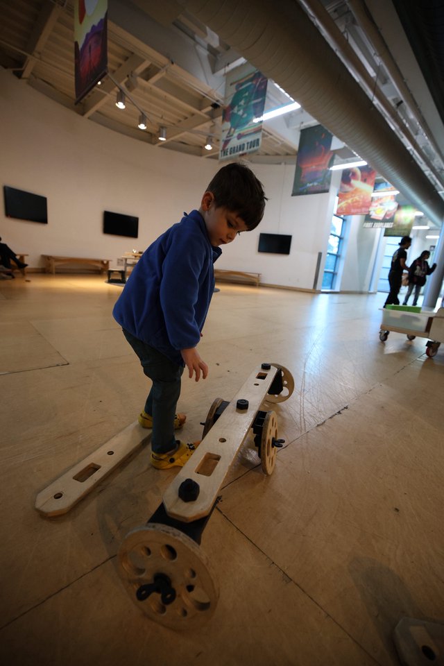 Child Exploring Interactive Wooden Balance Exhibit at Science Center
