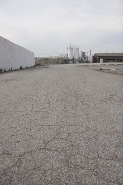 Abandoned Parking Lot with Factory Views