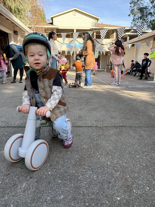 Young Child on Balance Bike at Neighborhood Party