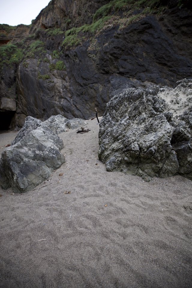 Dark Coastal Cliffs Frame Sandy Cove Passage