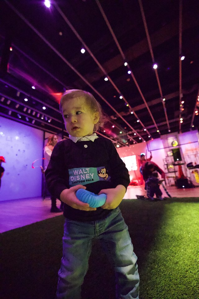 Young Child at Baby Rave Event Under Neon Lights