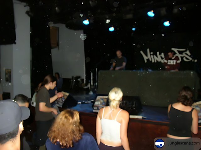 Nightclub Crowd Gathers Around DJ on Stage