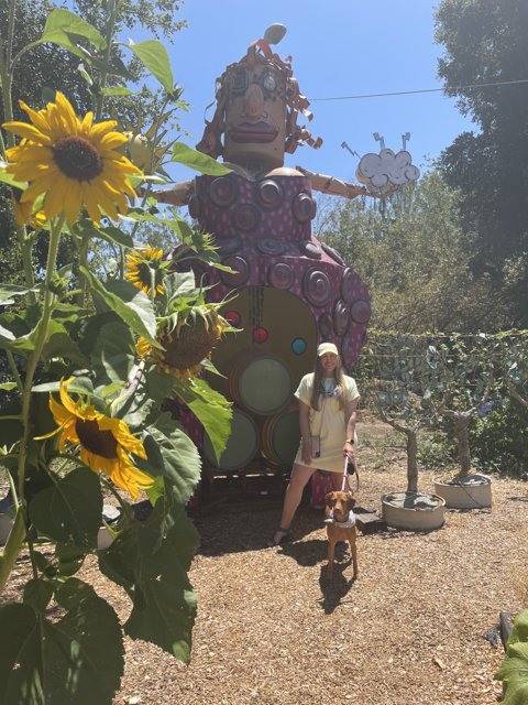 Woman and Dog Admire Giant Herbal Statue