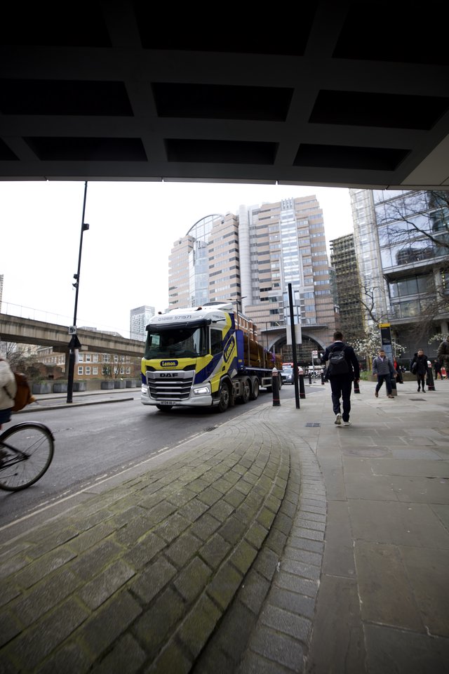 Heavy Truck Navigating Under Modern Urban Bridge