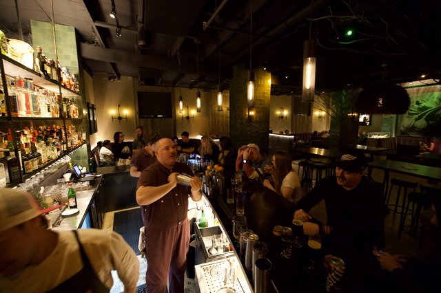 Bartender Mixing Craft Cocktails in Dimly Lit Modern Bar