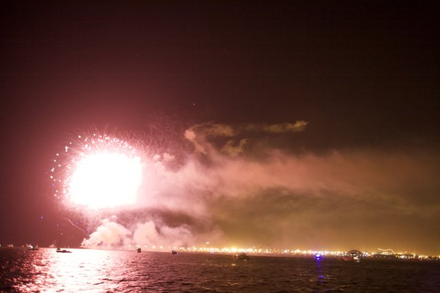 Glowing Fireworks Illuminate the Night Sky Above the Ocean