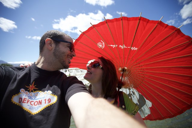 Couple Shares Joyful Moment Under Red Parasol
