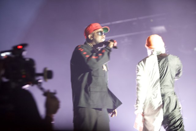 Two Men in Black Suits and Red Hats Perform on Stage
