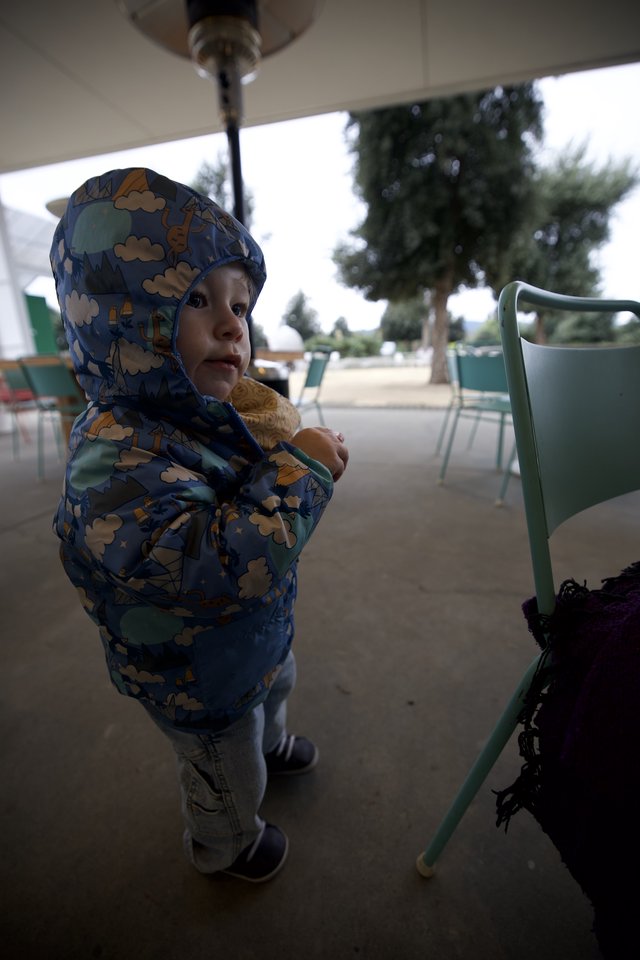 Toddler in Dinosaur Hoodie at Outdoor Café