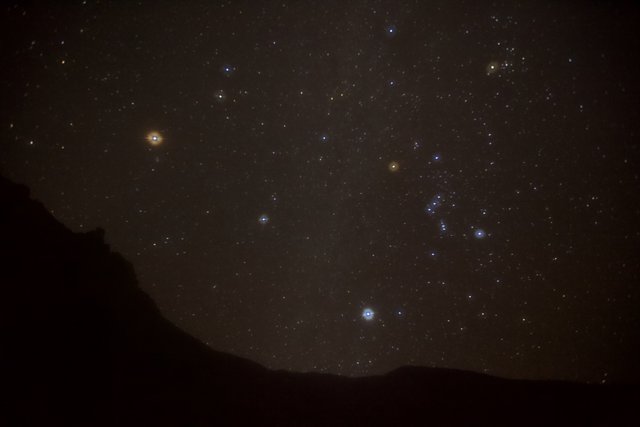 Orion Constellation shining brightly from the mountain peak