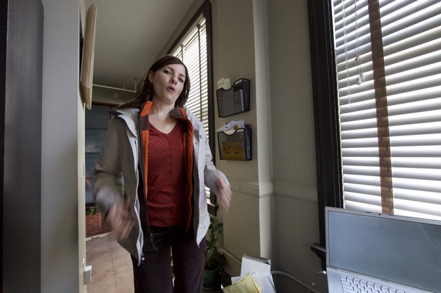 Woman Gesturing Expressively in Sunlit Office Doorway