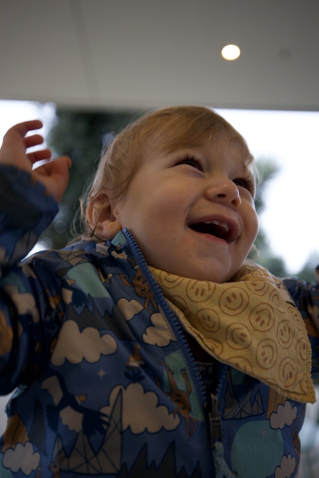 Joyful Toddler Laughing Under Outdoor Porch Ceiling