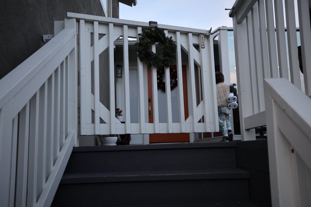 Child on Winter Deck with Holiday Wreath