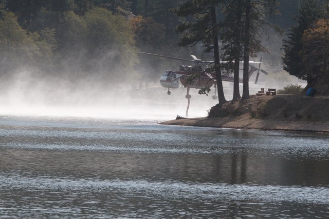 Helicopter surveillance over a misty lake