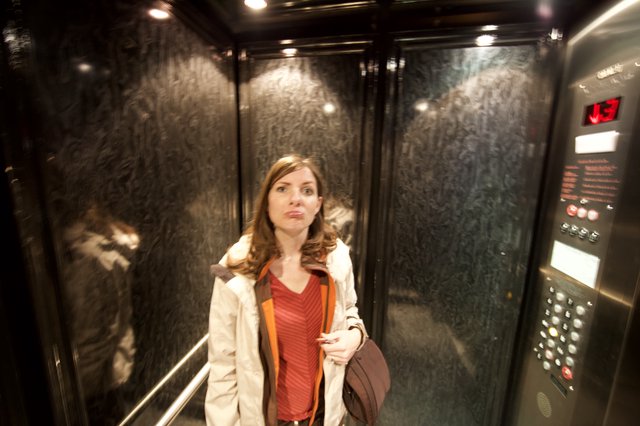 Woman Makes Funny Face in Dark Elevator