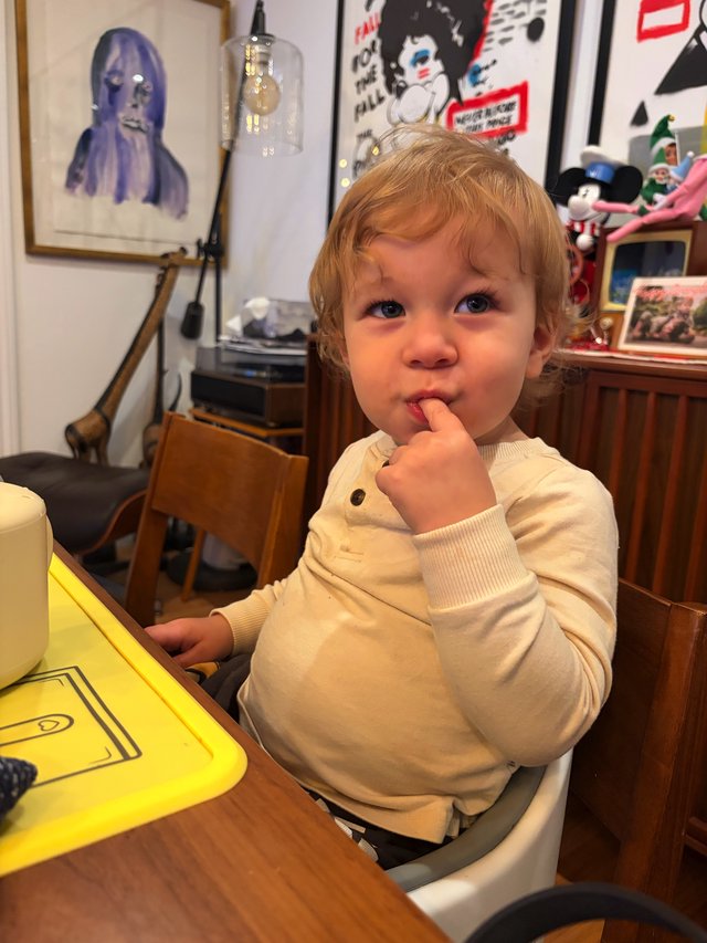 Toddler with Finger in Mouth at Home Table