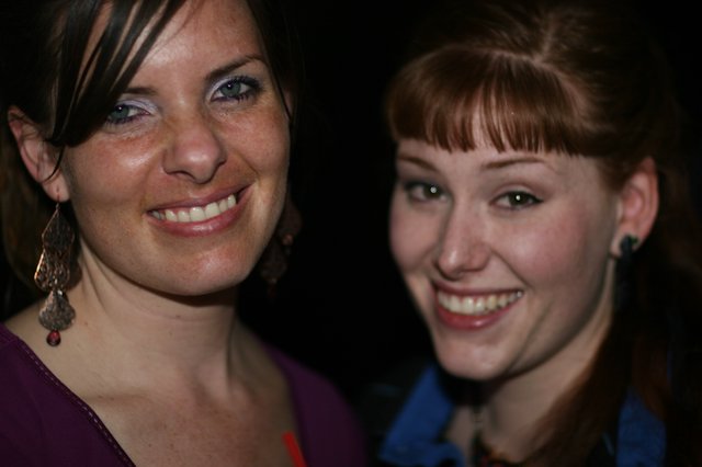 Two Smiling Women Posing Together at Night Event