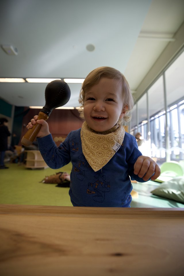 Joyful Toddler Playing with Wooden Hammer Toy