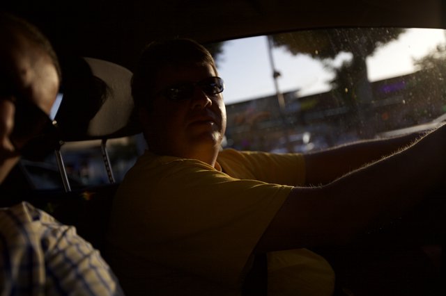 Silhouetted Driver in Golden Hour Urban Traffic