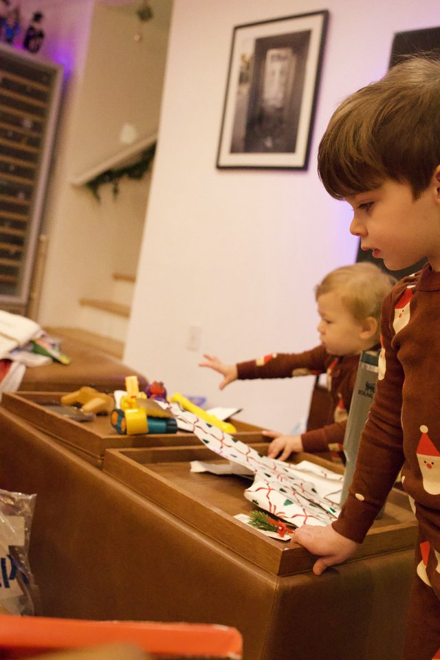 Brothers Unwrapping Christmas Presents Together at Home