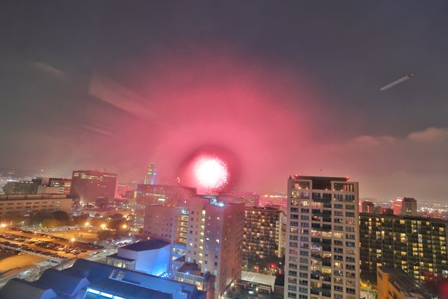 City Lights Bursting: A Fireworks Display over Urban Skyscrapers