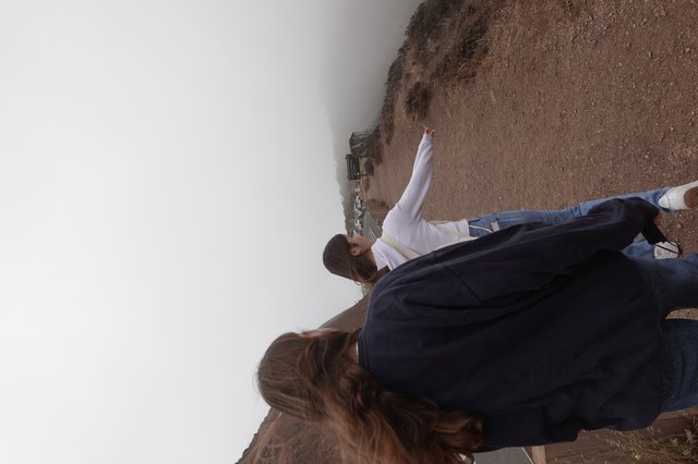 Two Women Walking on Foggy Coastal Trail
