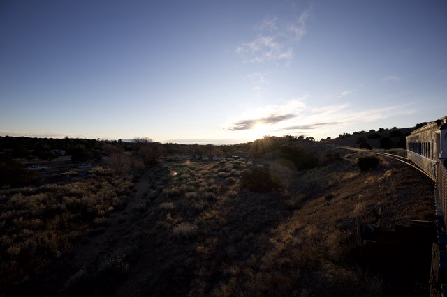Desert Sunset Over Scrubland and Distant Community