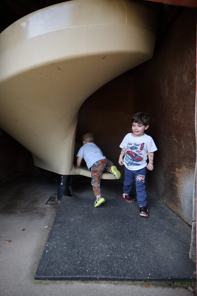 Children Playing on Curved Playground Slide at Dusk