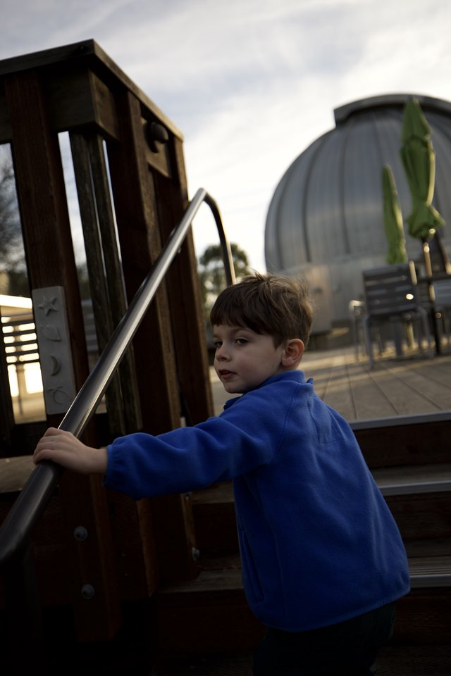 Young Boy at Modern Playground Structure at Dusk