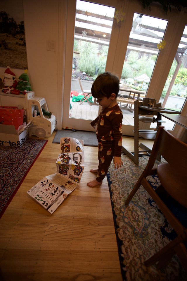 Toddler in Holiday Pajamas Playing with Puzzle at Home
