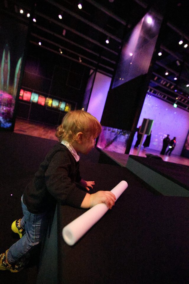 Child Exploring Interactive Light Installation at Museum