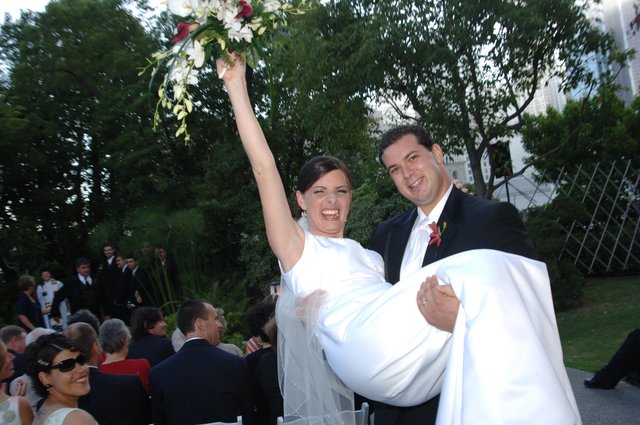 Jubilant Bride Carried by Groom After Outdoor Ceremony