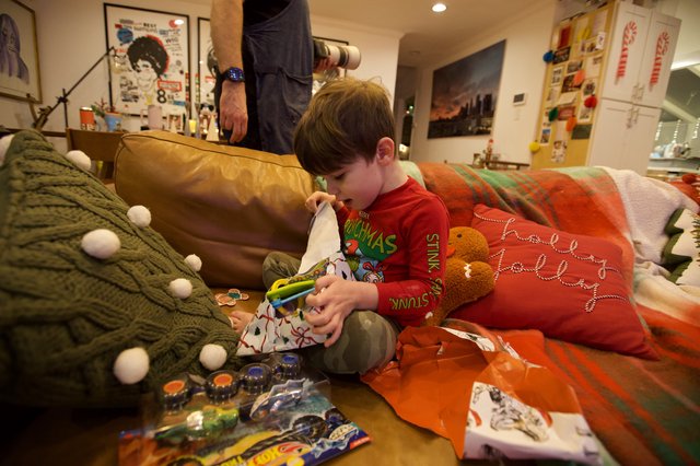 Child Opening Christmas Stocking on Cozy Living Room Sofa