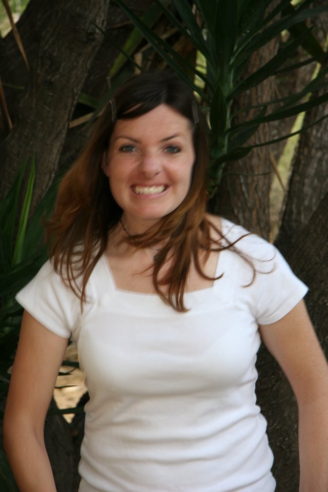 Smiling Young Woman Outdoors Among Tropical Foliage