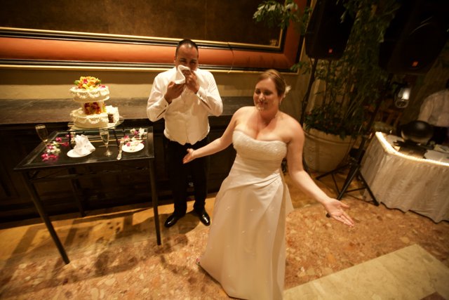 Wedding Couple Poses in Front of Luxurious Wedding Cake