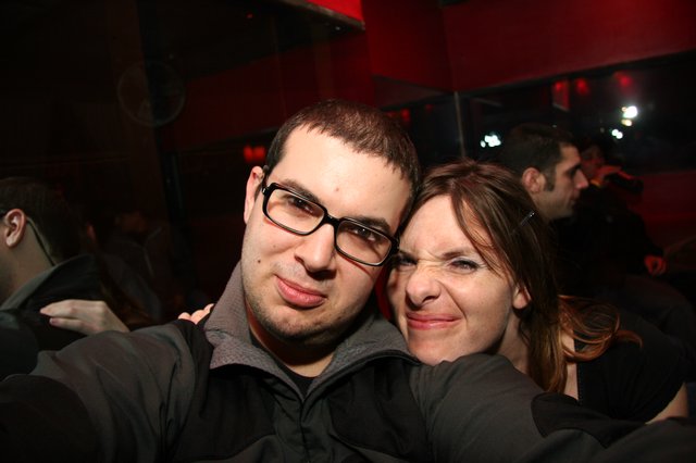 Friends Pose Together at Dimly Lit Night Venue