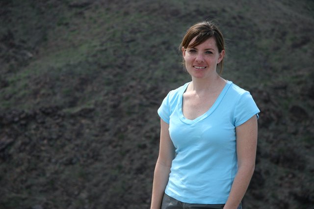 Young Woman Smiling Outdoors on Rocky Hillside