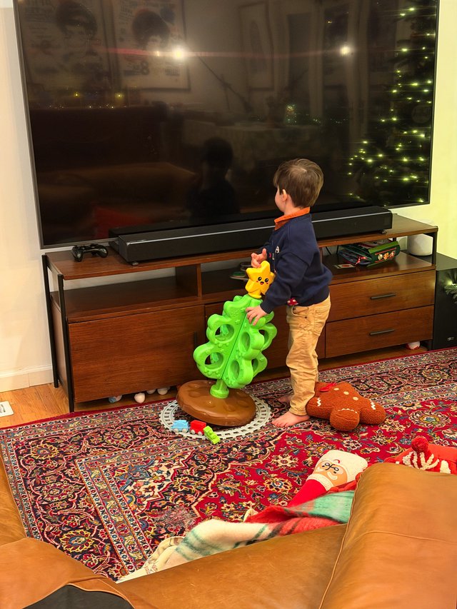 Young Child Playing with Bright Green Toy in Living Room