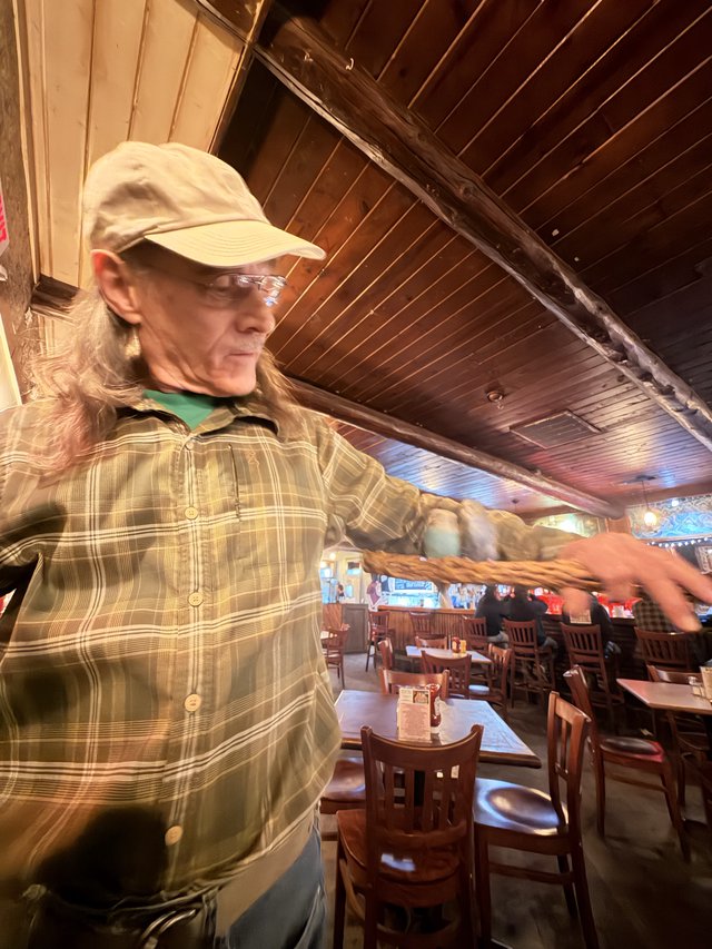 Long-Haired Patron Gesturing in Santa Fe Restaurant