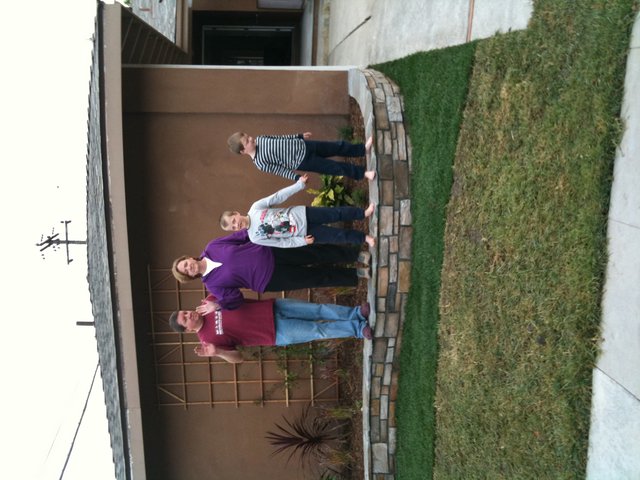 Family Waving Together in Front of Home
