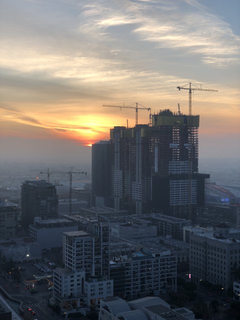 Urban Sunset with Construction Cranes