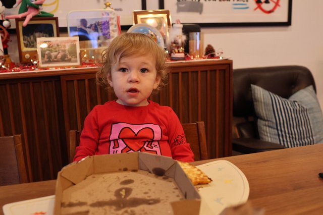 Toddler Enjoying Pizza at Christmas Dinner Table