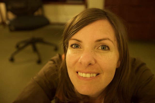 Smiling Woman with Blue Eyes in Office Setting